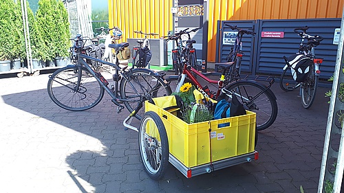 Mein Fahrrad mit dem beladenen Lastenanhänger vorm Baumarkt